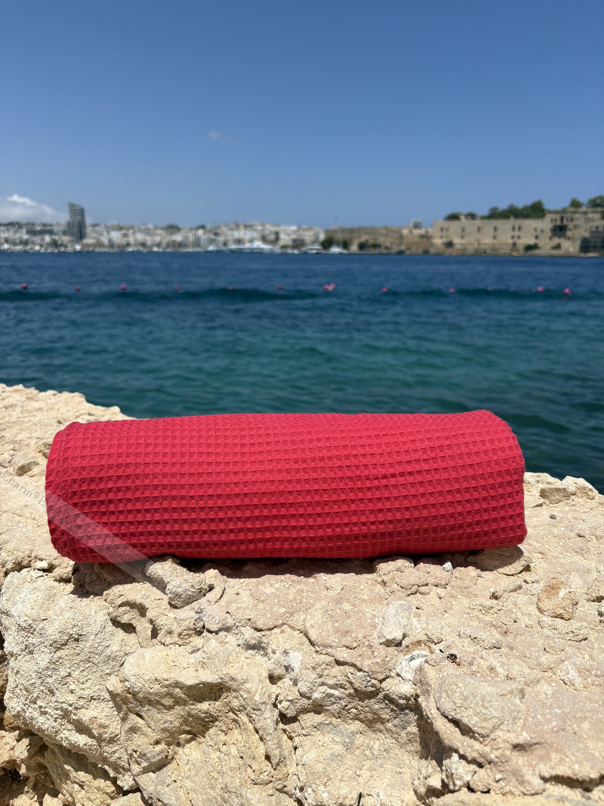 Strandtuch 70×200 cm in Rot – ausgebreitet auf Sonnenliege am Strand